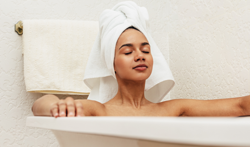 woman relaxing in bath wearing towel on head