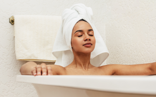 woman relaxing in bath wearing towel on head