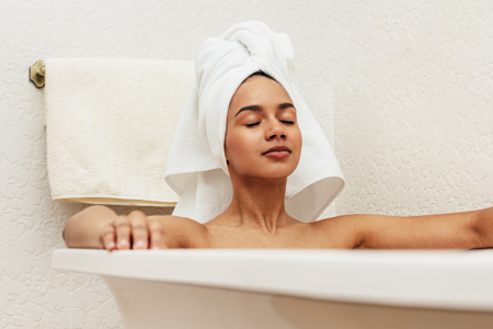 woman relaxing in bath wearing towel on head